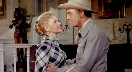 Adele Jergens as Reva Cairn and Randolph Scott as Jackson 'Sugarfoot' Redan, discussing marriage and finances in Sugarfoot (1951)