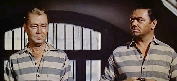 Alan Ladd as Peter Van Hoek, aka The Dutchman, and Ernest Borgnine as John McBain, about to be released from prison in The Badlanders (1958)