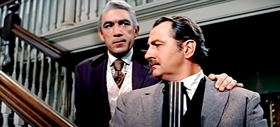 Anthony Quinn as Tom Morgan, talking to a bouncer to make sure Blaisedell stays safe in Warlock (1959)