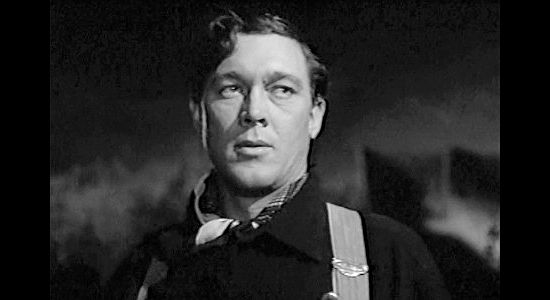 Ben Johnson as Travis Blue, reacting to the arrival of the Clegg gang at the wagon train's campsite in The Wagon Master (1950)