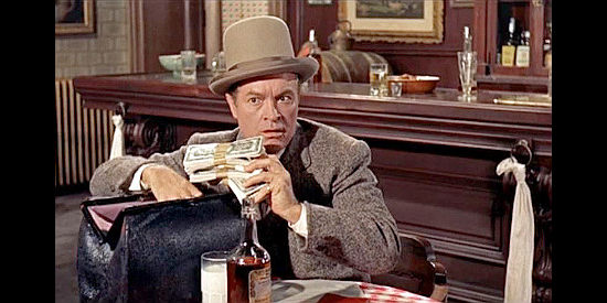 Bob Hope as Milford Farnsworth, stunned when a client turns over a satchel full of cash to pay the premium on a $100,000 life insurance policy in Alias Jesse James (1959)