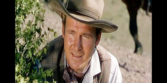 Charles Drake as Sgt. Schermerhorn, peeking around a bush at the Kiowa as they gather for an attack in War Arrow (1953)