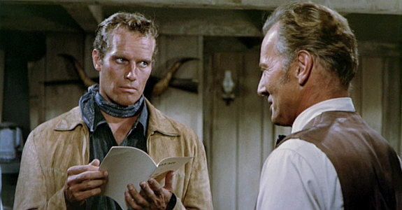 Charlton Heston as Colt Saunders, presented a tax bill by Commisioner Harrison (Bruce Bennett) in Three Violent People (1957)