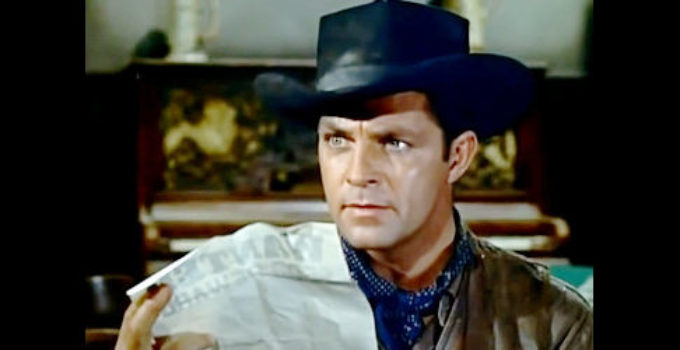 Dale Robertson as John Banner, presented with a wanted posters in Dakota Incident (1956)