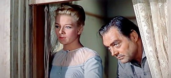 Dolores Michaels as Jessie Marlowe and Whit Bissell as Petrix, watching a wild bunch of cowboys ride into town in Warlock (1959)