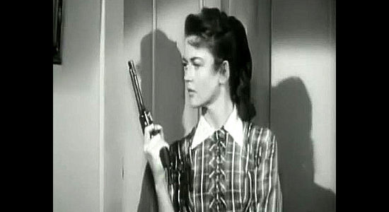 Dorothy Malone as Cathy Sharpe, ready to shoot the intruder she found in her bedroom if necessary in The Bushwhackers (1952)