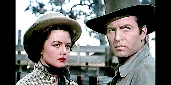 Dorothy Malone as Charlotte Downing and George Montgomery as Cruze, realizing they have a common interest in The Lone Gun (1954)