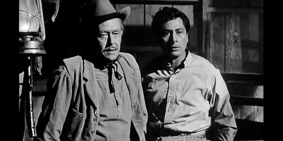 Forrest Lewis as Sheriff Silas Parker and Victor Millan as Manuel, watching a man being beaten in Apache Ambush (1955)