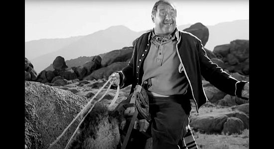 George Tobias as Ghazili, aboard his camel, asking Ford Smtih for water in Desert Pursuit (1952)