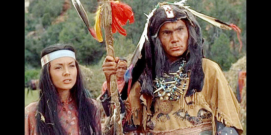 Jil Jarmyn as Nona and John Colicos as medicine man Chino, expecting Riva to be punished for refusing women's work and suggesting she become a warrior in War Drums (1957)