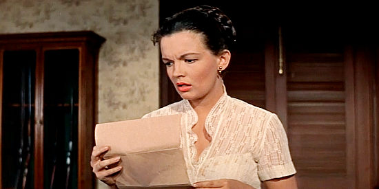 Joan Evans as Anne Benson, discovering papers that indicate why her dad might be Joe Gant's target in No Name on the Bullet (1959)