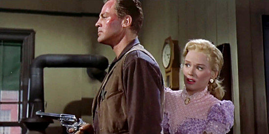 John Agar as Sheriff Bill Jordan, ready for any unexpected visitor to his office while fiancee Ellen Ballard (Mamie Van Doren) hides behind him in Star in the Dust (1956)