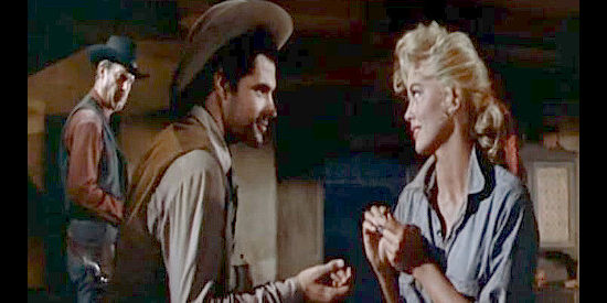 John Gavin as Teach, giving Chaney (Dorothy Malone) a set of earrings as Genry (Fred MacMurray) looks on in Quantez (1957)