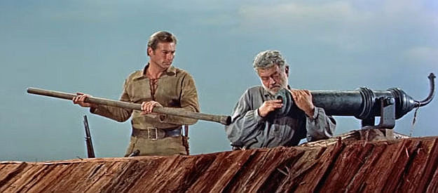 Lex Barker as Deerslayer and Jay Flippen as Tom Hutter, loading the cannon that sits atop his fortified boat in The Deerslayer (1957)