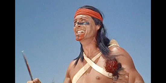 Lex Barker as Mangas Coloradas, celebrating the taking of a white man's scalp in War Drums (1957)