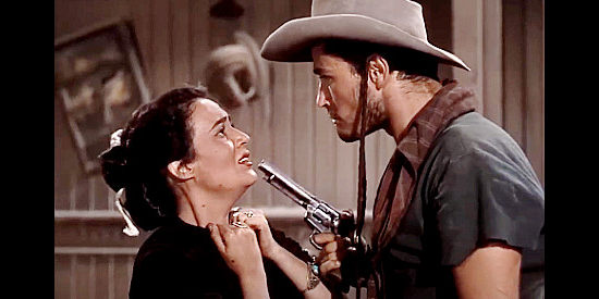 Maria Elena Marques as the Navajo girl, being threatened at gunpoint by The Kid (John Derek) in Ambush at Tomahawk Gap (1953)