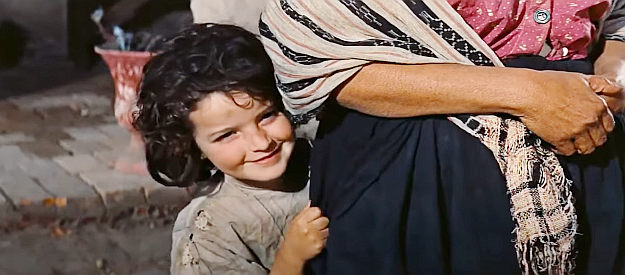 Maria Gracia as Helen, Jim's daughter, peeking at her father as he returns home for a visit in The Bravados (1958)