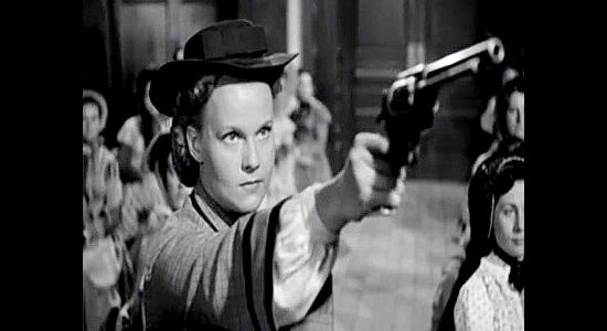 Marilyn Erkskine as Jean Johnson, demonstrating her shooting skills for Buck Wyatt in Westward the Women (1951)