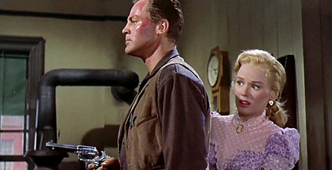 John Agar as Sheriff Bill Jordan, ready for any unexpected visitor to his office while fiancee Ellen Ballard (Mamie Van Doren) hides behind him in Star in the Dust (1956)