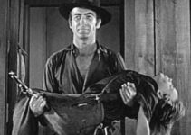 Mark Stevens carrying away the body of a young boy caught in a shoot-out in Jack Slade (1953)