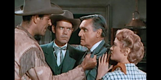 Rod Cameron as Tom Clay confronting Arthur Pickett (Morris Ankrum) about the lack of supplies reaching the Osage tribe while Travers (John Ridgely) and Ann (Jane Nigh) look on in Fort Osage  (1952)