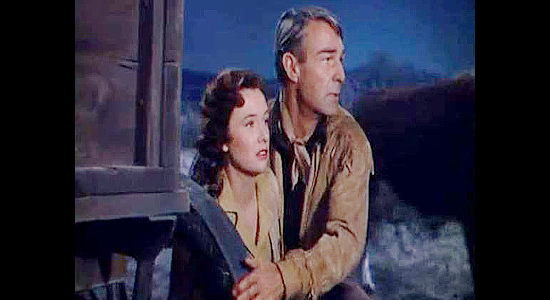 Randolph Scott as Ned Britt, protecting Flora Talbot (Phyllis Thaxter) during a cattle stampede in Fort Worth (1951)