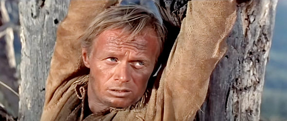 Richard Widmark as Comanche Todd, chained to a tree by a sheriff in The Last Wagon (1956)