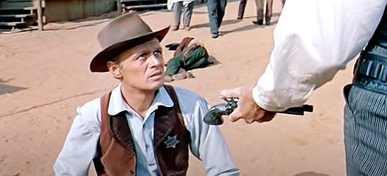 Richard Widmark as Johnny Gannon, offered Clay Blaisedell's gun after a shooting in Warlock (1959)