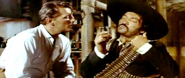 Robert Mitchum as Wilson, trying to free Lisa Kennedy from the grasp of a revolutionary lieutenant named Gonzalez (Jose Torvay) in Bandido! (1956)
