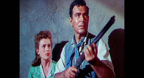 Stephen McNally as Sam Leeds, prepared to defend Sally (Coleen Gray) against the Apach attack in Apache Drums (1951)