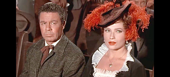 Valerie French as Ruby James, accompanied by Dr. Storrow (John Archer) and insisting on sitting in the front pew to watch her lover marry another woman in Decision at Sundown (1957)