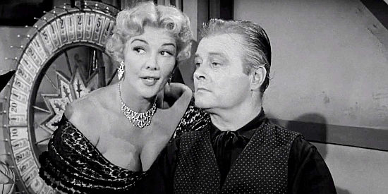 Veda Ann Borg as Susan Stark, whispering a secret about a new saloon employee to Sonny Glenn (Tom Brown) in Naked Gun (1956)