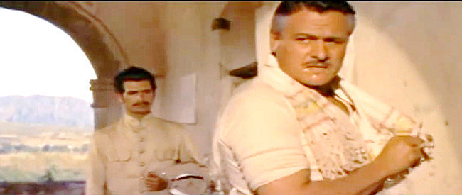 Victor Junco as Gen. Lorenzo, hoping Lisa Kennedy can learn the location of a cache of weapons in Bandido! (1956)