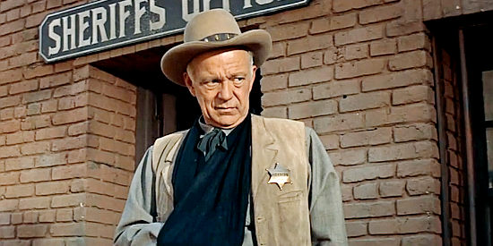 Will Bouchey as Sheriff Hastings, wounded and unable to do anything about the killer who's come to town in No Name on the Bullet (1959)