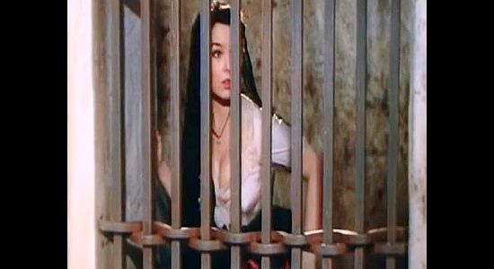 Yvonne Craig as Elena de la Madrid, watching Hatfield Carnes' movements from the presumed safety of the jail in The Young Land (1959)