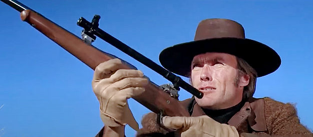 Clint Eastwood as Joe Kidd, about to try out one of the high-powered rifles used by Frank Harlan's men in Joe Kidd (1972)
