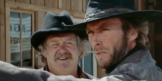 Clint Eastwood as The Stranger, giving Sheriff Sam Shaw (Walter Barnes) ideas on how to defend his town in High Plains Drifter (1973)