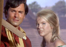 George Maharis as Paul Cardenas and Janet Landgard as Kate Mayfield, surveying the aftermath of an Indian attack in Land Raiders (1969)