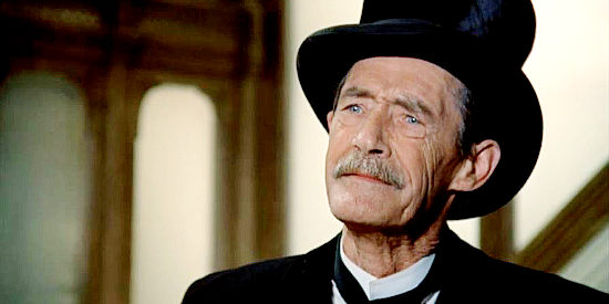 John Carradine as Beckum, the undertaker, negotiating to handle J.B. Brooks' funeral in The Shootist (1976)