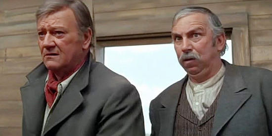 John Wayne as Wil Andersen and Slim Pickens as Anse Peterson, entering the school house looking for cowhands in The Cowboys (1972)