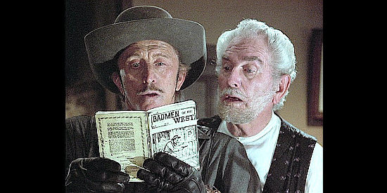 Kirk Douglas as Cactus Jack, relying on a dime novel for bank robbery tips as the bank clerk (Foster Brooks) looks on in The Villain (1979)