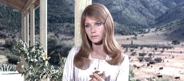 Pamela McMyler as Sallie Chisum, John Chisum's niece, holding a cross given to her by Billy in Chisum (1970)