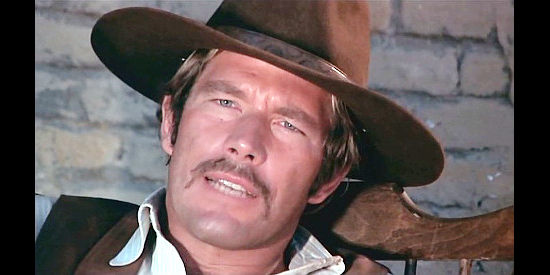 Richard Harrison as Sheriff Donovan, explaining why he's sent the man suspected of robbing the bank in search of the bank robbers in Reverend Colt (1970)