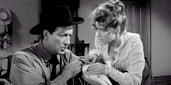 Robert Taylor as Mackenzie Bovard, dealing with a minor wound with the help of Selah Jennison (Tina Louise) in The Hangman (1959)
