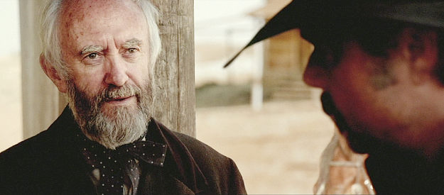 Jonathan Pryce as Mayor Nathan Keane, listening to Delarue's latest demands in The Salvation (2014)