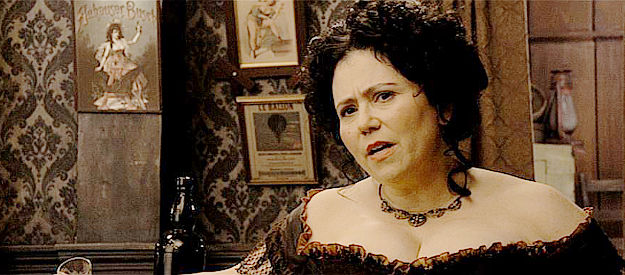 Alex Borstein as Millie, brothel owner, questioning Edward about his relationship with one of her whores in A Million Ways to Die in the West (2014)