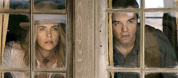 Charlize Theron as Anna and Seth MacFarlane as Albert watching Clinch and his gang approach the sheep farm in A Million Ways to Die in the West (2014)