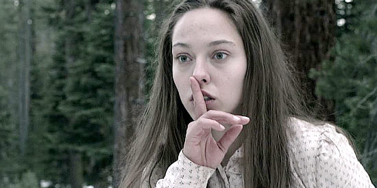 Jasmin Jandreau as Amelia, signaling for the Indian boy to be quiet, fearful she'll be discovered by others in The Trail (2013)