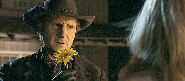 Liam Neeson as Clinch, returning a special daisy to Anna (Charlize Theron) in A Million Ways to Die in the West (2014)