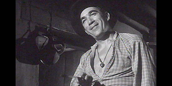 Anthony Quinn as Bob Kallen, threatening Hamish with his knife skills in The Ride Back (1957)